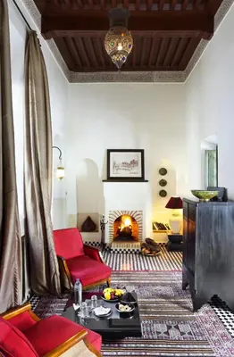 a living room with a couch and a fireplace at Le Farnatchi in Marrakech