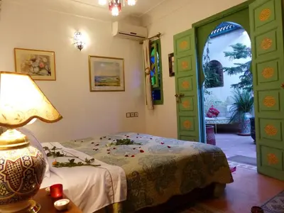 a bedroom with a bed and a lamp on a table at Riad Cherihane in Marrakech