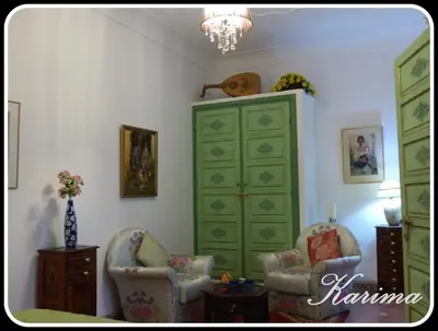 a living room with two chairs and a green dresser at Riad Cherihane in Marrakech