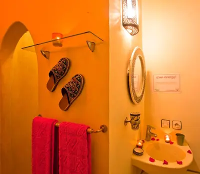 a bathroom with red towels and a sink at Riad Cherihane in Marrakech