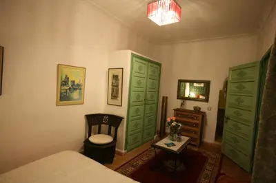 a bedroom with green doors and a bed and a table at Riad Cherihane in Marrakech