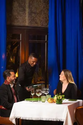 two men and a woman sitting at a table with wine glasses at La Villa des Orangers - Relais & Châteaux in Marrakech