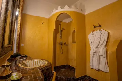 a bathroom with a shower and a robe hanging on a wall at Riad Alaka in Marrakech