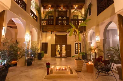 a large lobby with a fireplace in the middle of a building at Riad Hizad in Marrakech