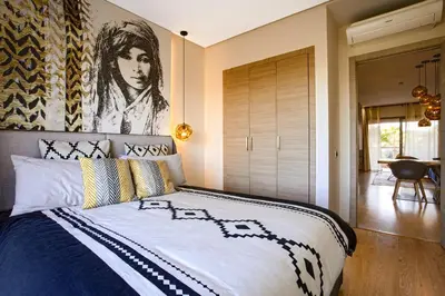 a bedroom with a bed with a painting on the wall at Darkech Prestigia Luxury Apt in Marrakech