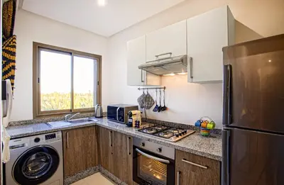 a kitchen with a refrigerator and a stove top oven at Darkech Prestigia Luxury Apt in Marrakech