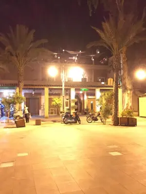 a parking lot with palm trees in front of a building at Riad Le Marrakech Berrima in Marrakech