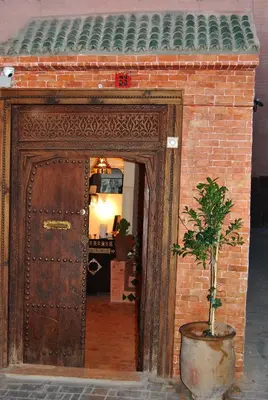 a large wooden door with a plant in front of it at Ryad Bianco in Marrakech