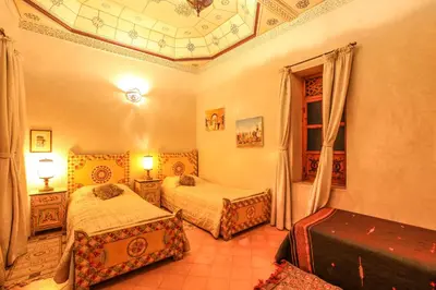 a bedroom with two beds and a coffered ceiling at Riad Puchka in Marrakech