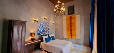 a bedroom with a bed and a chandelier at Riad de Vincent in Marrakech