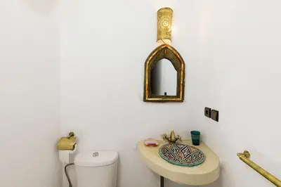 a bathroom with a sink and a toilet and a mirror at Riad Wardate Rita in Marrakech