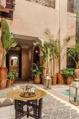 a table in the middle of a building with plants at Dar Beija in Marrakech