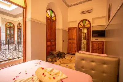 a room with a bed and a view of a balcony at Riad Aymane in Marrakech