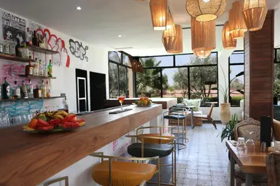 a bar in a restaurant with a counter and chairs at Boutique Hotel Katia in El Harkat