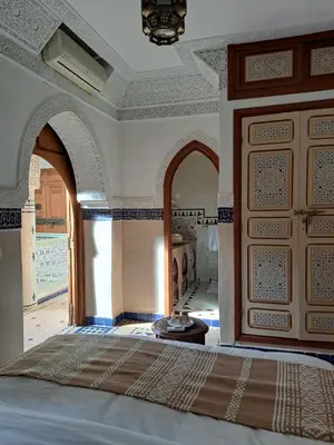 a bedroom with a bed and arches and a room at Dar Al Kounouz in Marrakech