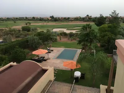 a view of the golf course from the balcony of a resort at Villa entière GOLF MARRAKECH in Marrakech