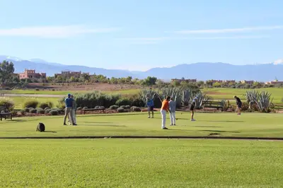 a group of people playing golf on a golf course at Villa entière GOLF MARRAKECH in Marrakech