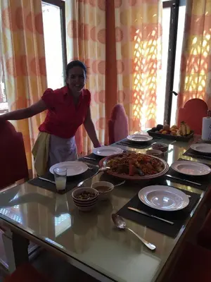 a woman standing in front of a table with food at Villa entière GOLF MARRAKECH in Marrakech