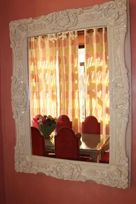 a mirror on a wall with two chairs and a table at Villa entière GOLF MARRAKECH in Marrakech