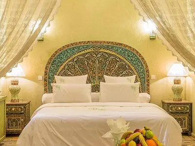 a bedroom with a large bed with a large headboard at Riad Tahyra in Marrakech