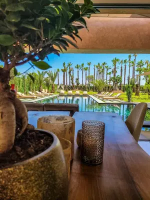 a table with a view of the pool at a resort at Villa Oxygène Marrakech in Marrakech