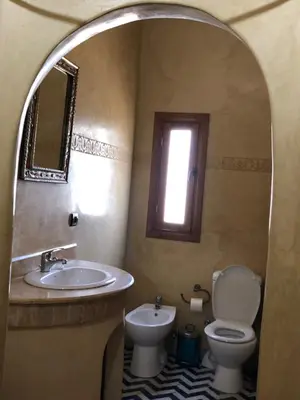 a bathroom with a sink and a toilet and a window at Riad Mhidou in Marrakech