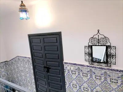 a room with a black door and a mirror at Riad Ansar in Marrakech