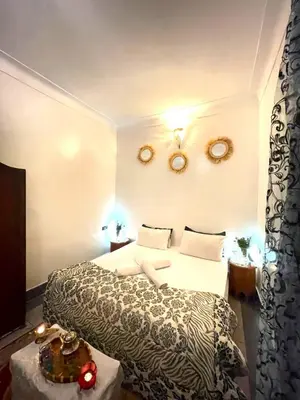 a hotel room with a bed and a table at Riad dar Assou in Marrakech