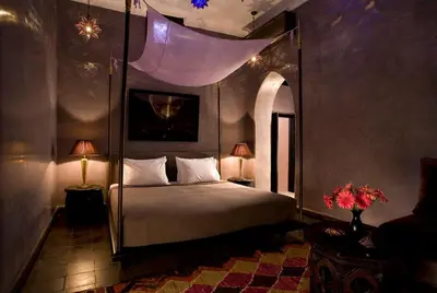 a bedroom with a large bed with a canopy at Riad Meriem in Marrakech