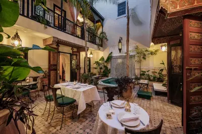 a restaurant with tables and chairs and plants at Riad Dar El Souk in Marrakech