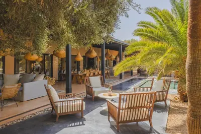a resort with a pool and chairs and palm trees at Villa Taj Marrakech in Marrakech
