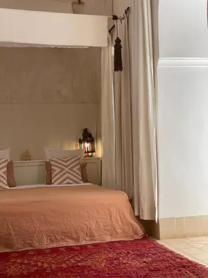 a bedroom with a bed with a orange bedspread at Dar El Qadi in Marrakech