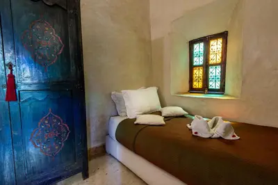 a bedroom with a bed with two babies sitting on it at Riad dar Ourika & SPA in Marrakech