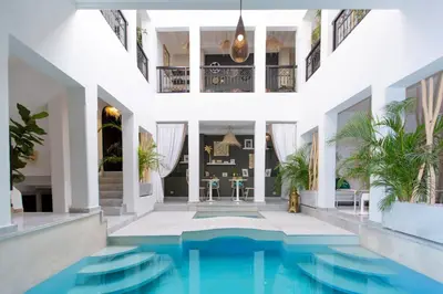 an indoor pool in a house with white walls and ceilings at Riad Al Rimal & Spa in Marrakech