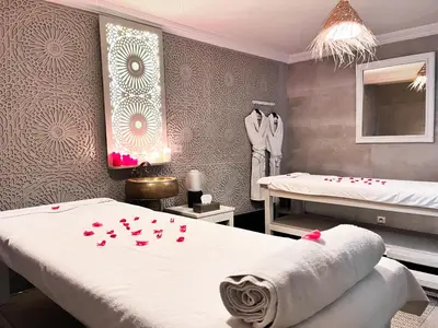 a bedroom with two beds and red roses on the wall at Riad Al Rimal & Spa in Marrakech