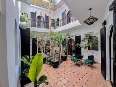 a courtyard with plants and chairs in a building at Riad Al Rimal & Spa in Marrakech