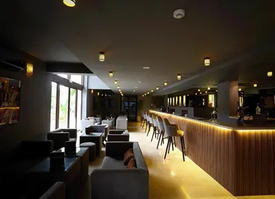 a restaurant with a bar with couches and chairs at Rawabi Hotel Marrakech & Spa in Marrakech