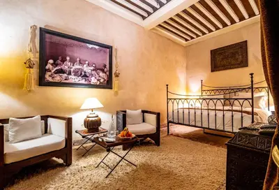 a living room with a bed and a couch and a table at Dar Les Cigognes in Marrakech