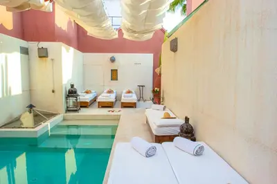 a room with four beds and a swimming pool at Riad Kaiss By Anika in Marrakech