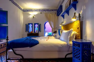a bedroom with a large white bed and a window at Riad Kaiss By Anika in Marrakech