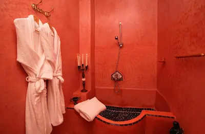 a bathroom with a shower with candles and towels at Riad Eden in Marrakech