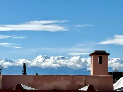 a building with a view of snow covered mountains at Riad la Cigale in Marrakech