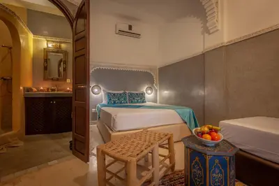 a bedroom with two beds and a table with a bowl of fruit at Riad Kech Soul Boutique & Spa in Marrakech
