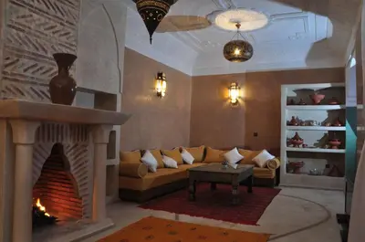 a living room with a couch and a fireplace at Riad Imilchil in Marrakech