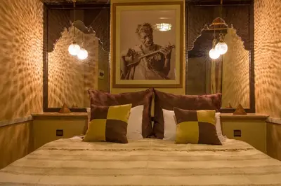 a bedroom with a bed with a portrait of a man at Riad L'Evidence in Marrakech