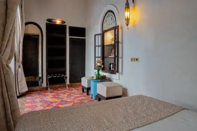 a bedroom with a bed and a table and chairs at Riad Khalifa in Marrakech