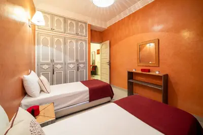 a hotel room with two beds and a mirror at Riad Appart Arwa in Marrakech