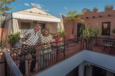 a man and a woman standing on a balcony at Riad Dar Attika in Marrakech
