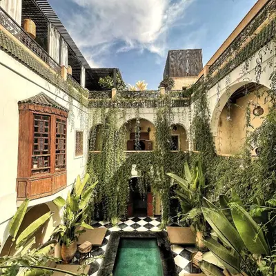 an ivy covered building with a swimming pool at Sakkan in Marrakech