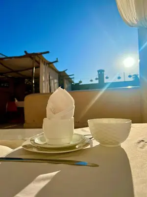 a table with two bowls and a cup on it at Riad Tizwa Marrakech in Marrakech